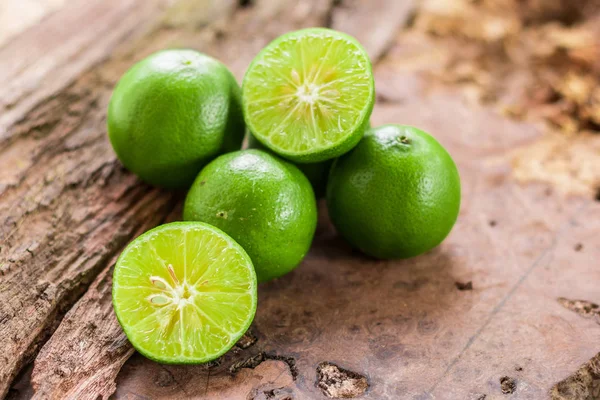 Green lemon - Lemon and Half of lemon citrus fruit with wooden background, Closeup shoot, Select focus.