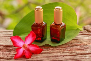 Spa Kozmetik Parfümeri Ürünleri - iki Spa kozmetik konteyner ve eski ahşap doku arka plan ile yaprak yeşil çöl gülü ayakta. Portre, Select odak. 
