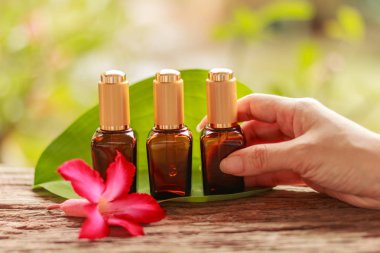 Bir pipet serum üç Spa kozmetik konteyner ile tutan el