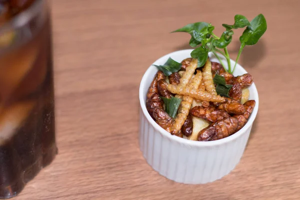 Böcekler - ahşap solucan, Silkworms kızarmış böcek, lezzetli patates kızartması ve ahşap arka plan beyaz tabakta yemek çubukları. Böcekler Kamboçya ve Tayland insanlar için tercih edilir. Odağı seçin