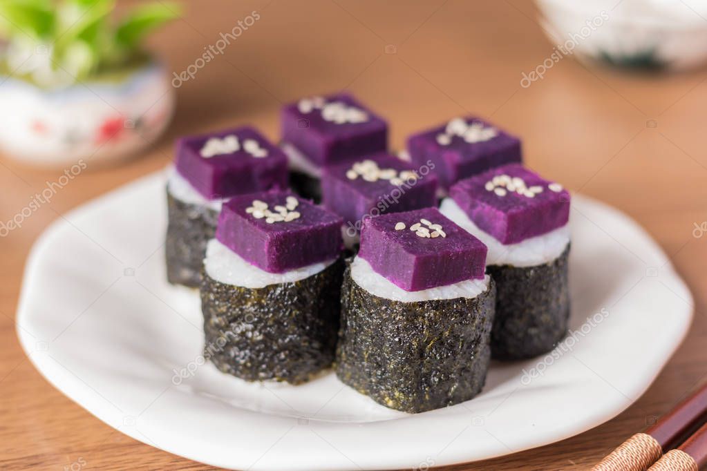 Sushi - Purple sweet potato in sushi rice with white ceramic plate. The benefits of purple sweet potato are high Beta Carotene and Carbohydrate used in cooking. Close up