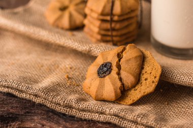 Çikolatalı kurabiye ve bir bardak süt üzerinde bir hessian üzerinde