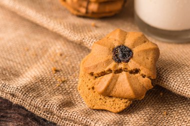Çikolatalı kurabiye ve bir bardak süt üzerinde bir hessian üzerinde