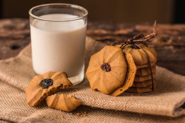 Çikolatalı kurabiye ve bir bardak süt üzerinde bir hessian üzerinde