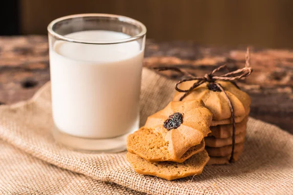 Çikolatalı kurabiye ve bir bardak süt üzerinde bir hessian üzerinde
