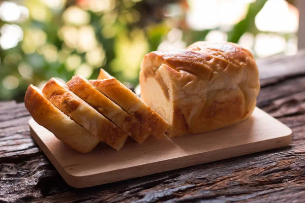 Brot in Scheiben - hausgemachte Brotscheiben auf einem Holzteller und einer Tasse — Stockfoto