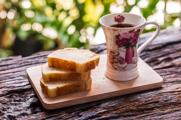 Pan rebanado - Rebanadas caseras de pan en un plato y taza de madera — Foto de Stock