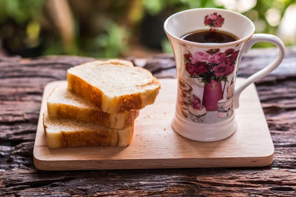 Pan rebanado - Rebanadas caseras de pan en un plato y taza de madera — Foto de Stock