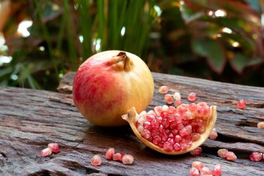 Dilimlenmiş güzel nar ve arka plan olarak eski koyu kahverengi ahşap tohumlar. Kapat..