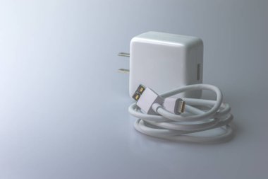 Gri arkaplanda telefon için USB kablosu ile beyaz elektrik şarj