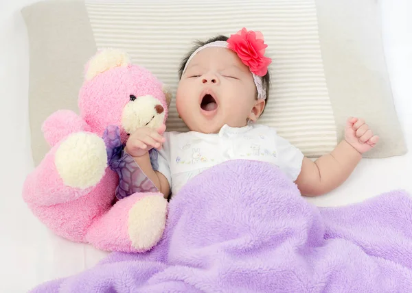 Retrato de adorável bebê menina acordar na cama com urso boneca — Fotografia de Stock