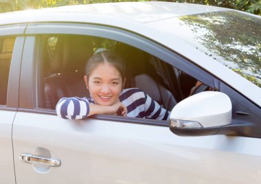 Güzel Asyalı kız gülümseyerek ve araba panosunda dokunmadan