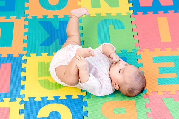 Retrato de una niña pequeña y adorable tumbada boca arriba Fotos de stock libres de derechos