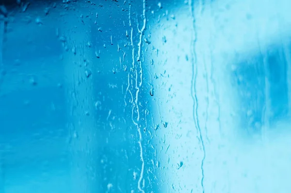 Raindrops on window glass, toned blue, tilt shift — Stock Photo, Image