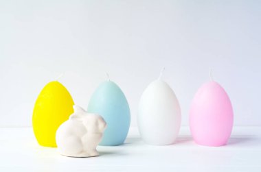 (Ostara, Eoster) Paskalya tavşanı beyaz arka plan kopya alanı ile yumurta şeklinde mum ile