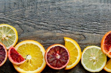 Sliced and cut Sicilian blood oranges on wooden natural background, top view clipart