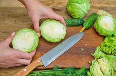 Taze lahana ahşap kesme tahtası üzerinde kesme eller