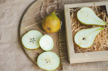 Kağıt, ambalaj arka plan üzerinde olgunlaşmış ve sulu armut tuval çuval bezi ve tonda ve soluk ahşap masa,