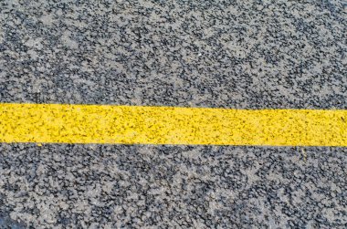 Arka plan ve sarı yol işaretleri olarak taze asfalt