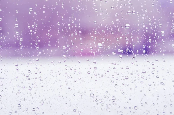 Gotas de chuva e água congelada no fundo de vidro da janela, tonificação roxa — Fotografia de Stock