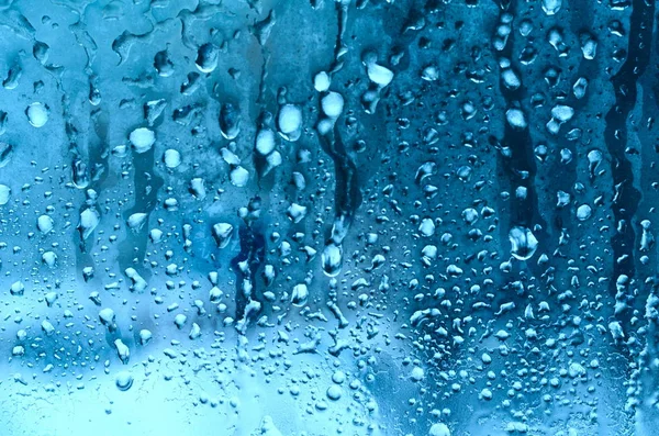 窗玻璃背景下的雨滴和冰冻水 — 图库照片
