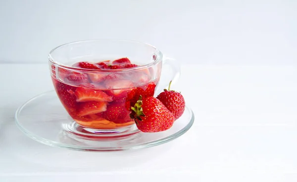 Φράουλα τσάι σε ένα διαφανές φλιτζάνι που απομονώνονται σε λευκό φόντο — Φωτογραφία Αρχείου