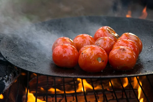 Grillad rostas tomatoed på en varm stekpanna över öppen eld — Stockfoto