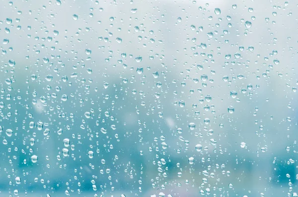 Gotas de chuva e água congelada no fundo de vidro da janela, tonificação azul — Fotografia de Stock