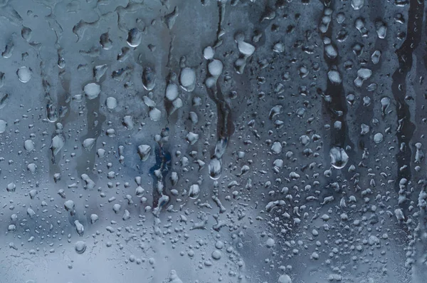 窗玻璃背景下的雨滴和冰冻水 — 图库照片