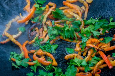 Açık ateş üzerinde sıcak bir kızartma tavası Közlenmiş biber ızgara