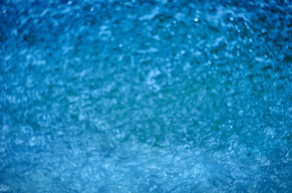 Bokeh ve güneş yansımaları ile mavi su doğal arka plan bulanık — Stok fotoğraf