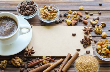 Sağlıklı aperatifler - fındık ve kuru üzüm doğal ahşap zemin üzerine siyah espresso kahve fincan. Kopya alanı zanaat defter ile orta.