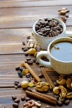 Sağlıklı aperatifler - fındık ve kuru üzüm doğal ahşap zemin üzerine siyah espresso kahve
