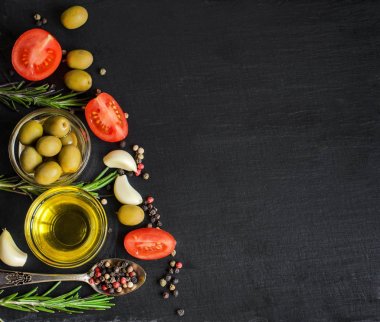 Zeytinyağı ve maddeler için sağlıklı bir vejetaryen salata - cherry domates, zeytin, sarımsak ve biberiye kopya alanı metniniz için doğal siyah arduvaz zemin üzerine Üstten Görünüm