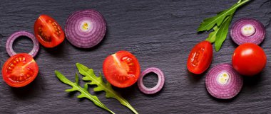 Kiraz domates ve soğan doğal siyah arduvaz arka plan üzerinde sağlıklı bir salata için malzemelerle kopya alanı metni üzerinde afiş Üstten Görünüm