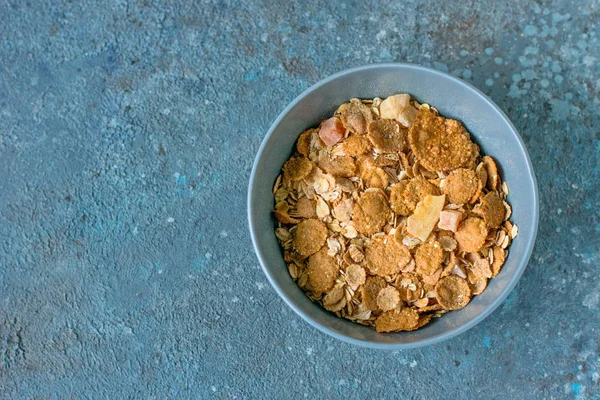 Bowl of oatmeal cereals breakfast on a blue cement and concrete background, table setting — Stock Photo, Image