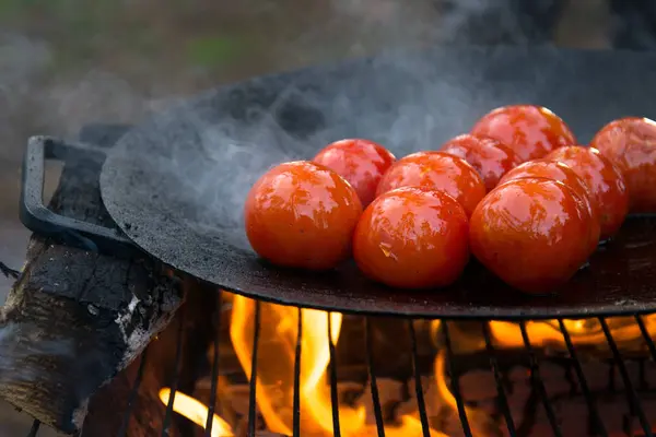 Gebratene Tomaten auf einer heißen Pfanne auf offenem Feuer gegrillt — Stockfoto