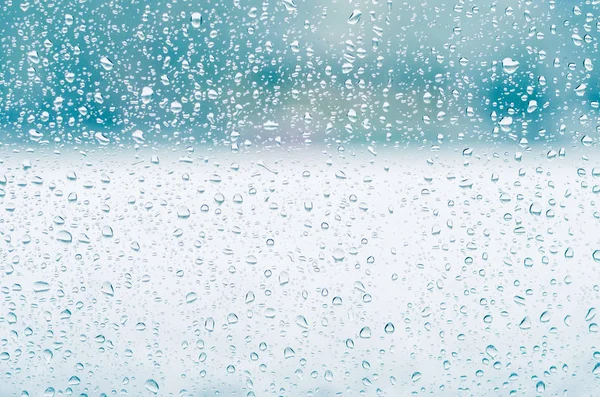 Regentropfen und gefrorenes Wasser auf Fensterglashintergrund, blaue Tonung — Stockfoto