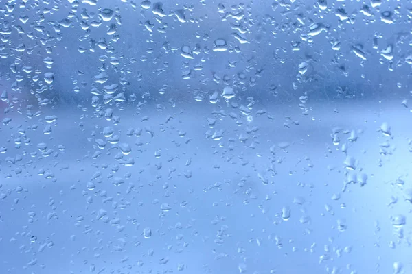 Gocce di pioggia su vetro pulito finestra blu — Foto Stock