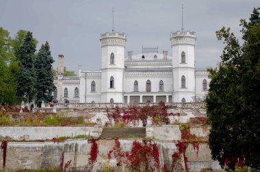 White gothic ruined palace in autumn. Sharovka, Ukraine.