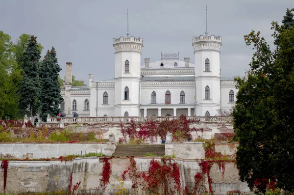White gothic ruined palace in autumn. Sharovka, Ukraine.