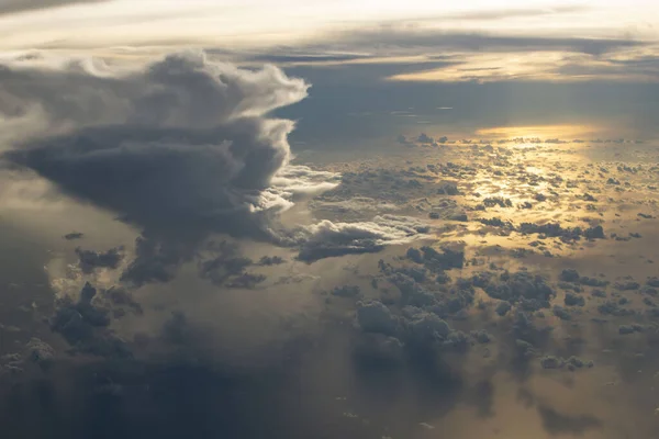 Clouds over the ocean during sunset from airplane window