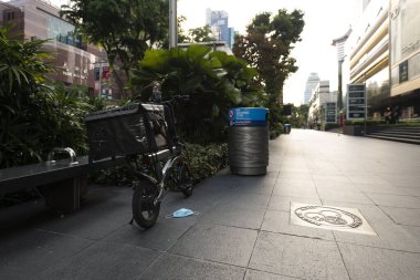 SINGAPORE, SINGAPORE - APR 10, 2020: Food deliveryElectric Scooter parked on an empty street of Orchard Road, Singapore during Circuit Breaker or Lockdown due to increased rate of COVID-19 Infection