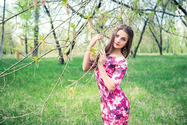 Beautiful girl holding hands branches of trees. Young woman in a forest park — Stock Photo, Image