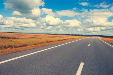 Güzel ve güneşli yol manzara gökyüzü bulutlar ve sarı alanlar ile