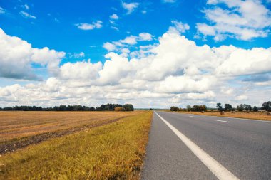 Güzel ve güneşli yol manzara gökyüzü bulutlar ve sarı alanlar ile