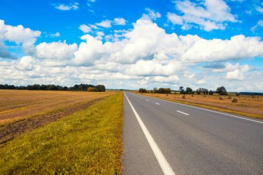 Güzel ve güneşli yol manzara gökyüzü bulutlar ve sarı alanlar ile