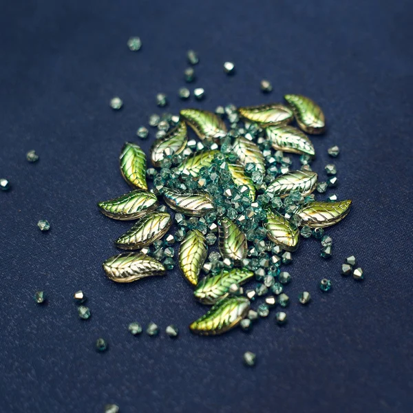 Красивые зеленые бусины и кристаллы рассеиваются на темном фоне — стоковое фото