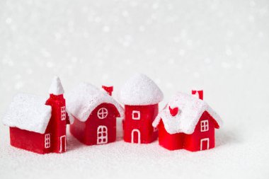 Beyaz arka planda kırmızı oyuncak evler, kış karlı çatıları olan Avrupa şehirleri konsepti