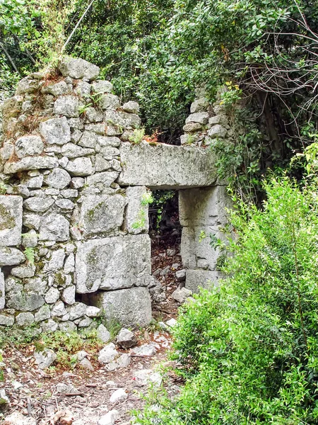 Ruiny wejścia do starożytnego miasta Olympos wśród t — Zdjęcie stockowe